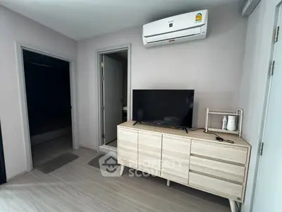 Modern living room with sleek wooden cabinet and mounted TV under air conditioning unit.
