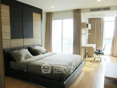 Modern bedroom with large window and study area, featuring sleek wooden flooring and contemporary design.