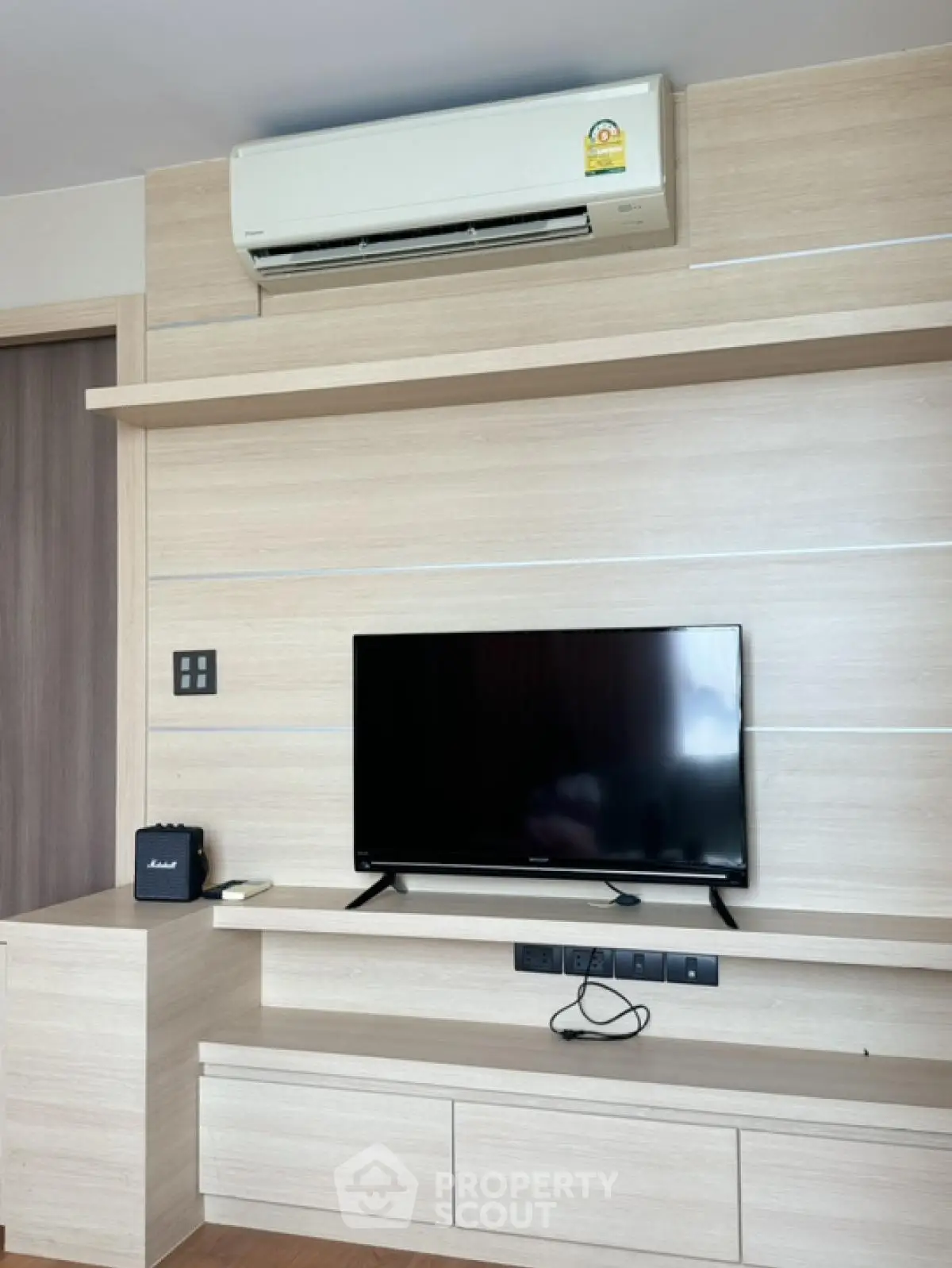 Modern living room with sleek TV setup and air conditioning unit