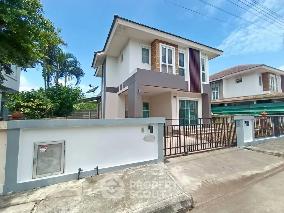 Modern two-story house with a gated entrance and contemporary design in a suburban neighborhood.