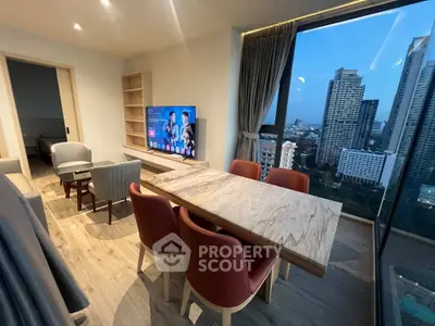 Modern living room with city view, stylish furniture, and large windows in a high-rise apartment.