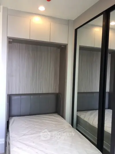 Modern bedroom with sleek mirrored wardrobe and cozy bed