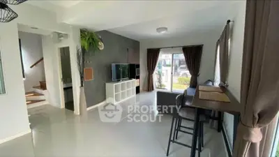 Modern living room with sleek design and natural light, featuring a cozy seating area and stylish decor.