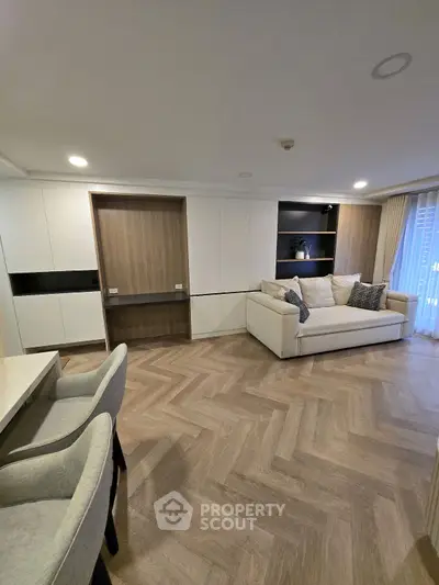 Spacious modern living room with elegant herringbone flooring and cozy seating area.