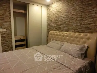 Cozy bedroom with stylish stone accent wall and modern furnishings