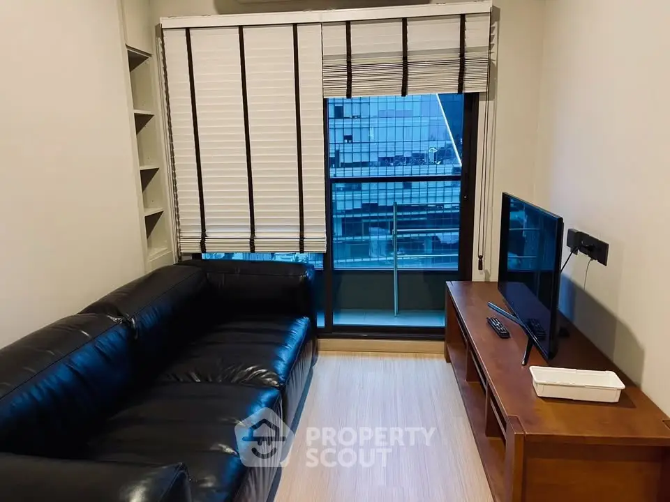 Modern living room with black leather sofa and city view balcony