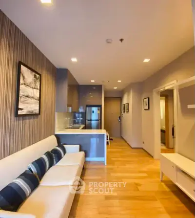 Modern living room with open kitchen and stylish decor in a contemporary apartment.