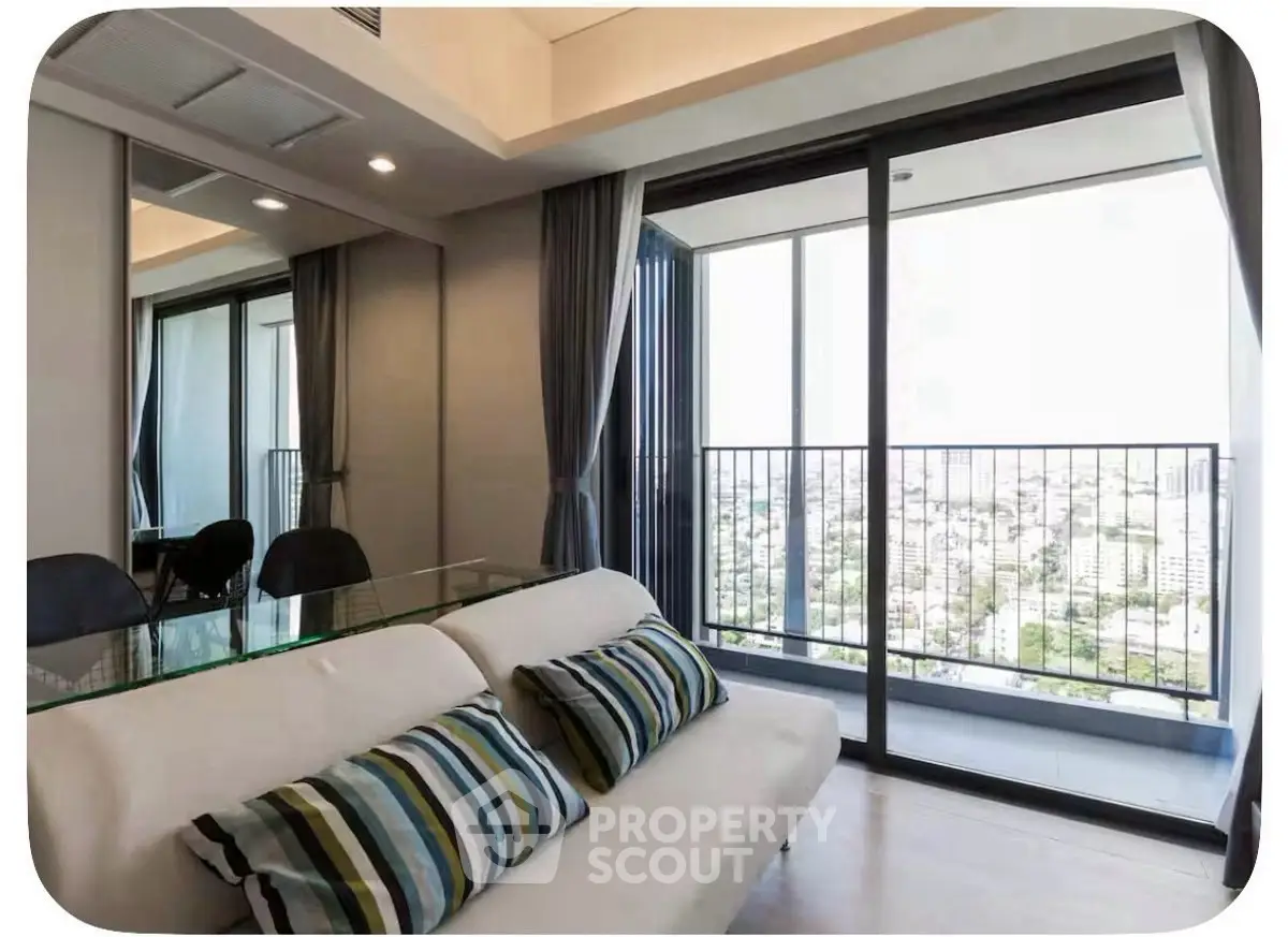 Modern living room with glass table and balcony offering stunning city view