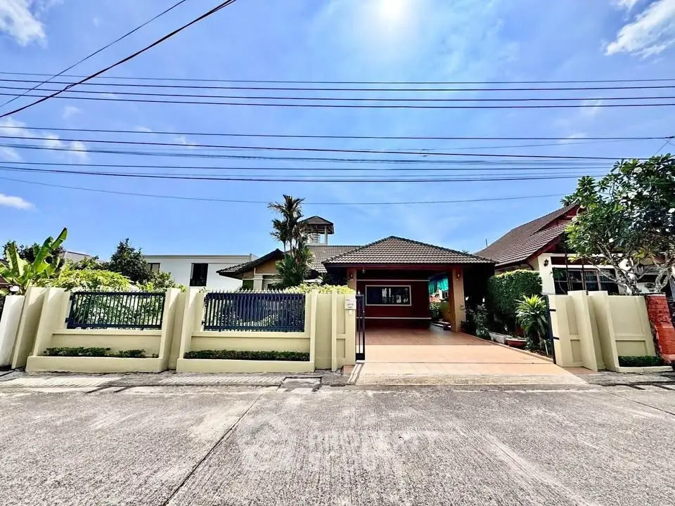 Charming suburban home with spacious driveway and lush greenery under a clear blue sky.