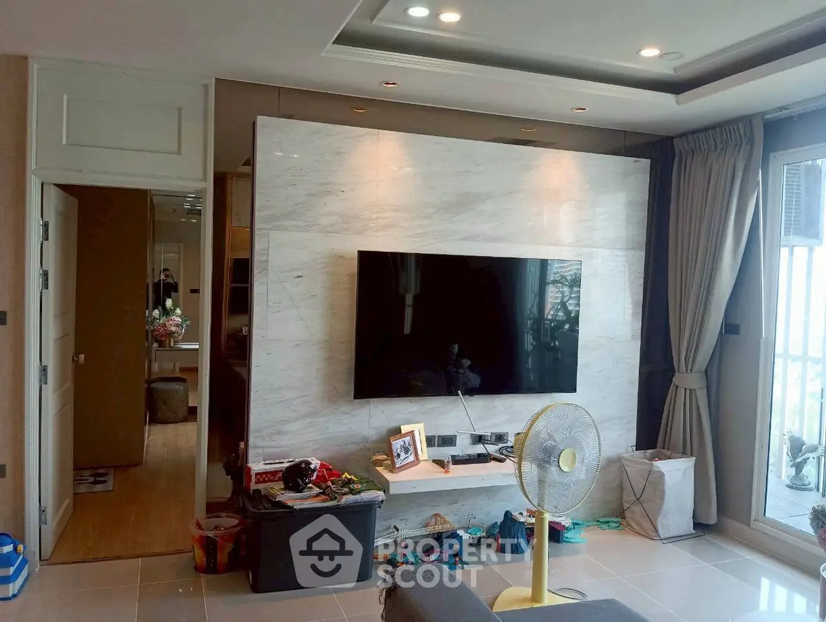 Modern living room with marble TV wall and large windows