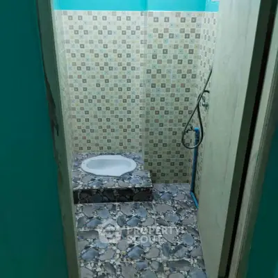 Compact bathroom with unique tile design and shower area.