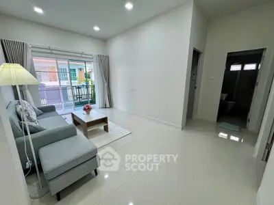 Spacious living room with modern decor and large window offering natural light.