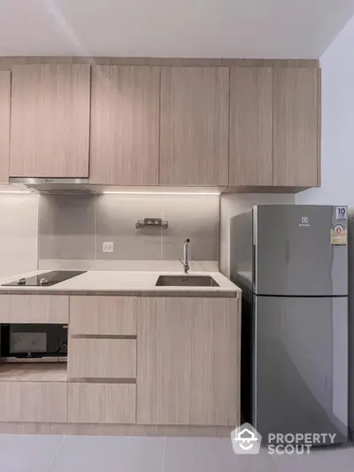 Modern kitchen with sleek cabinetry and stainless steel fridge