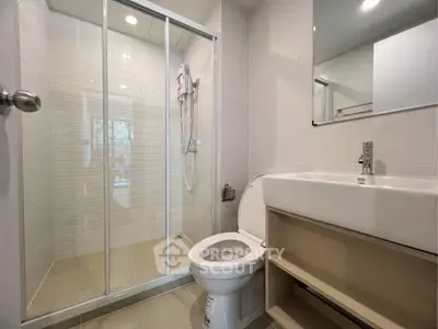 Modern bathroom with glass shower enclosure and sleek fixtures