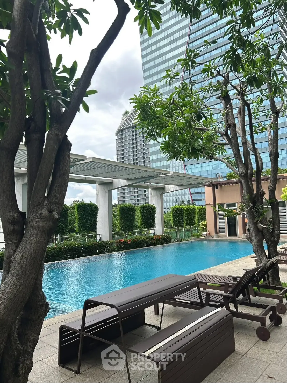 Luxurious rooftop pool with city skyline view and lush greenery.