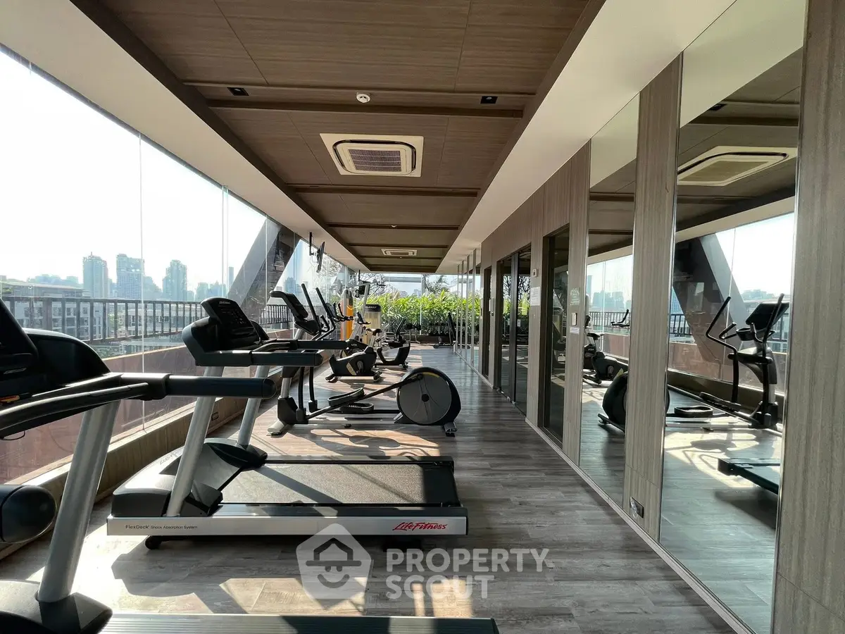 Luxurious rooftop gym with panoramic city views and modern fitness equipment.