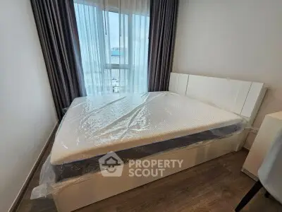 Modern bedroom with large window and new mattress in sleek apartment