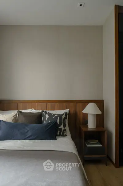 Modern bedroom with stylish decor and cozy ambiance, featuring elegant wooden accents and contemporary lighting.