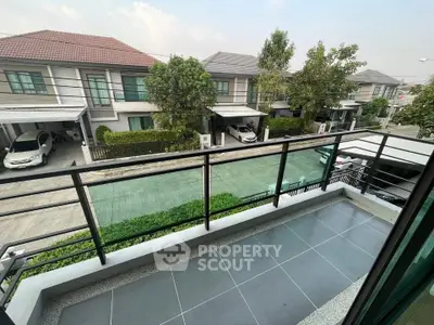Modern balcony with sleek railing overlooking suburban street and houses, perfect for relaxation.