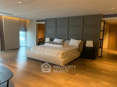 Spacious modern bedroom with elegant wooden flooring and stylish decor