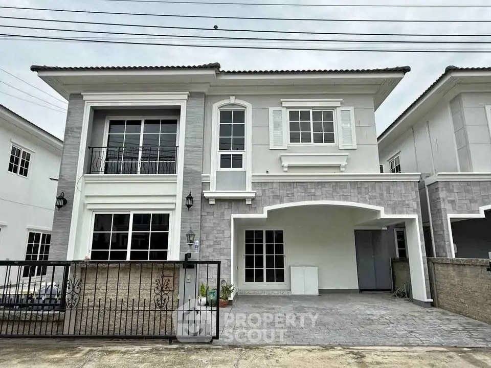 Elegant two-story house with modern facade and spacious driveway in a serene neighborhood.