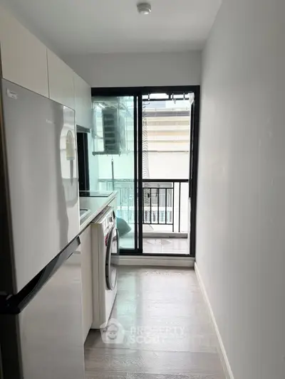 Modern kitchen with washing machine and balcony view in urban apartment