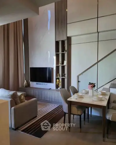 Modern living room with stylish dining area and wall-mounted TV in a contemporary apartment.