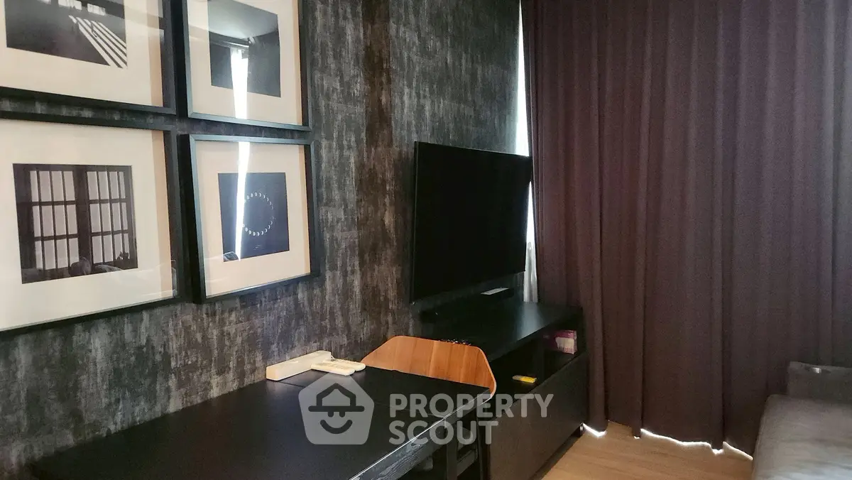 Modern living room with stylish decor and wall art, featuring a sleek TV setup and elegant curtains.