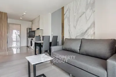 Modern living room with sleek gray sofa and marble accent wall