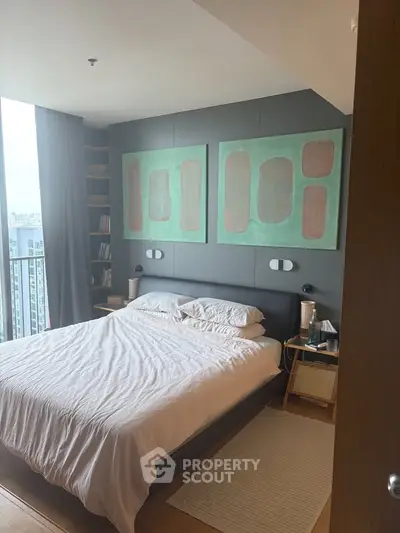 Modern bedroom with large windows and stylish decor in a high-rise apartment.