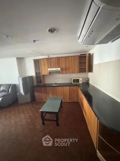 Spacious kitchen with wooden cabinets and modern appliances in open layout