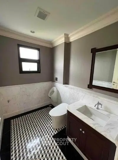 Elegant bathroom with modern fixtures and stylish black-and-white tile flooring.