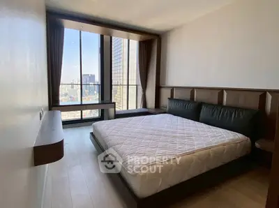 Modern bedroom with large window offering stunning city view, featuring sleek design and cozy atmosphere.