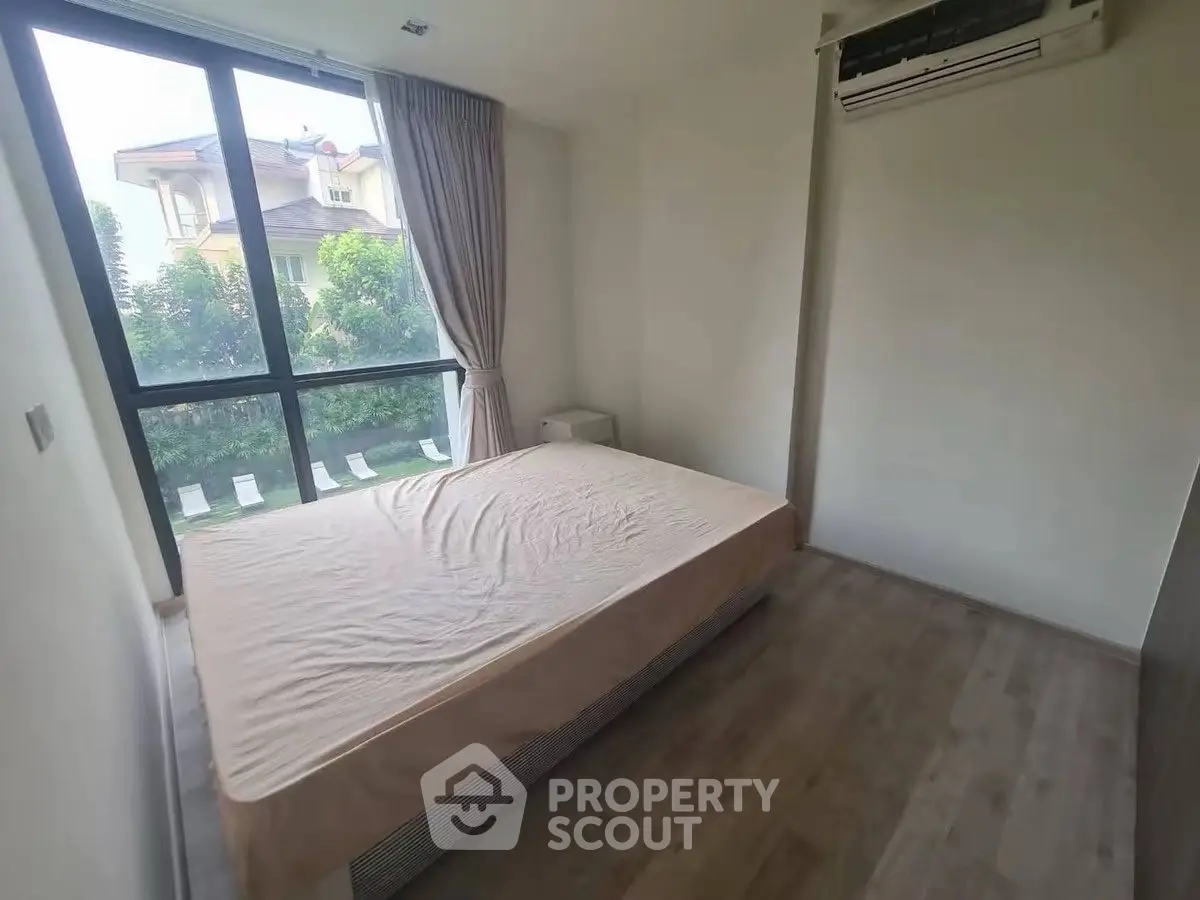 Spacious bedroom with large window and garden view in modern home