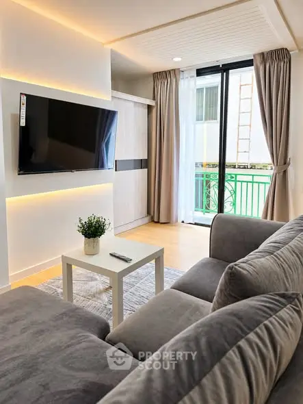 Modern living room with sleek design, featuring a wall-mounted TV and cozy seating area.