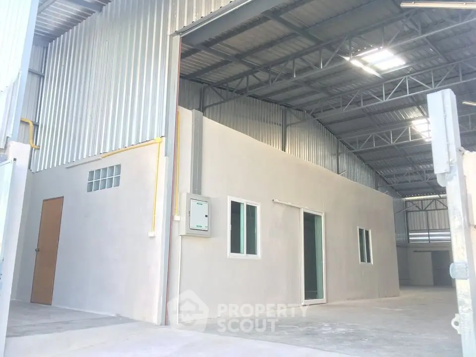 Spacious industrial warehouse with high ceilings and ample natural light.