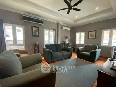 Cozy living room with plush sofas and natural light, perfect for relaxation.
