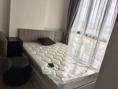 Cozy bedroom with large window offering natural light and city view, featuring a comfortable bed and modern decor.