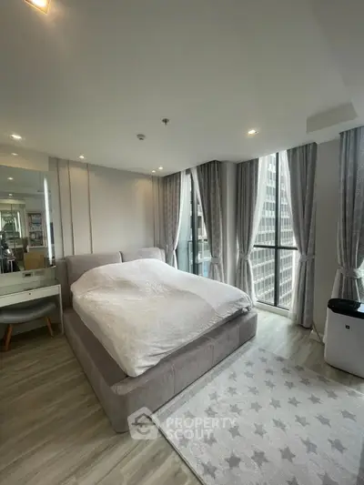 Luxurious bedroom with floor-to-ceiling windows and elegant decor in a modern high-rise apartment.