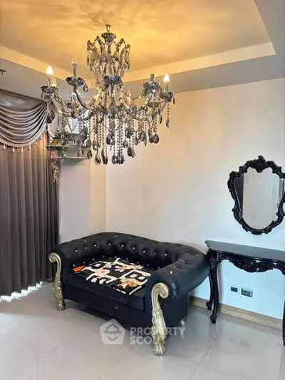 Luxurious living room with elegant chandelier and plush black sofa
