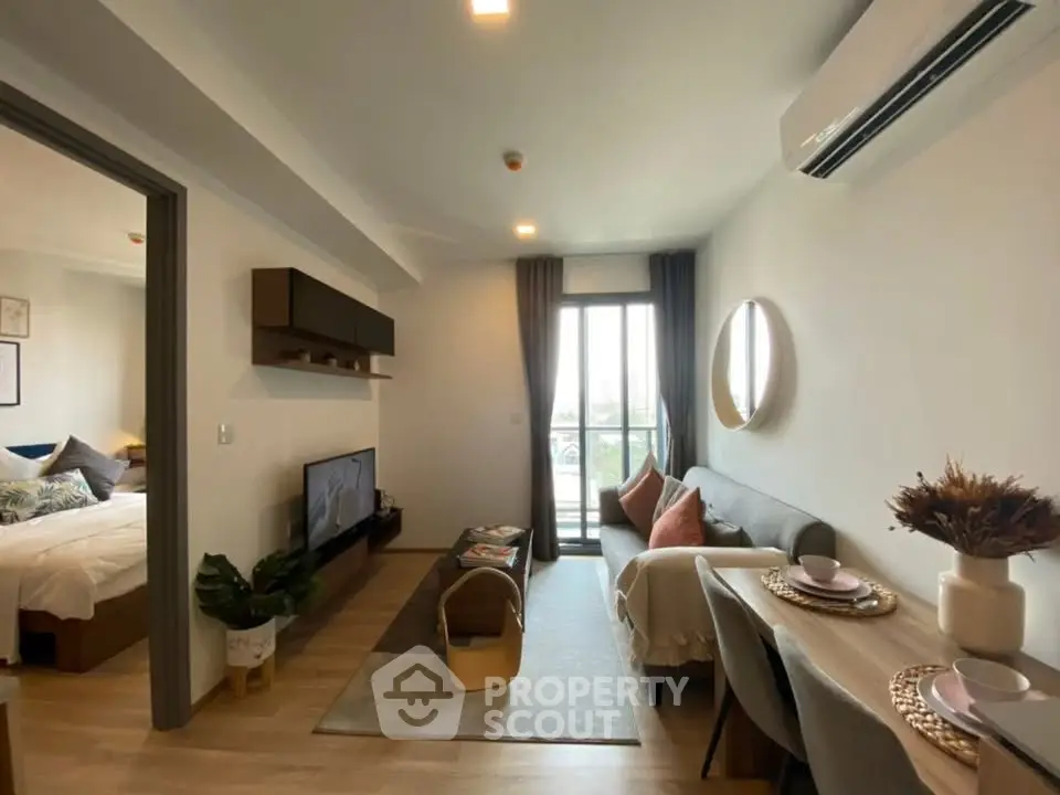 Modern living room with stylish decor and open layout, featuring a cozy dining area and balcony access.