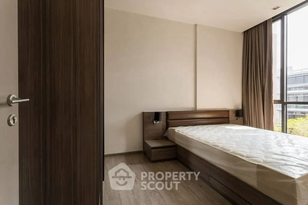 Modern minimalist bedroom with large window and wooden furnishings