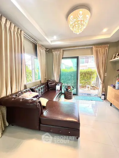 Luxurious living room with elegant chandelier and plush leather sofa