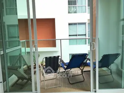 Charming balcony with cozy seating and modern glass doors, perfect for relaxation and enjoying the view.