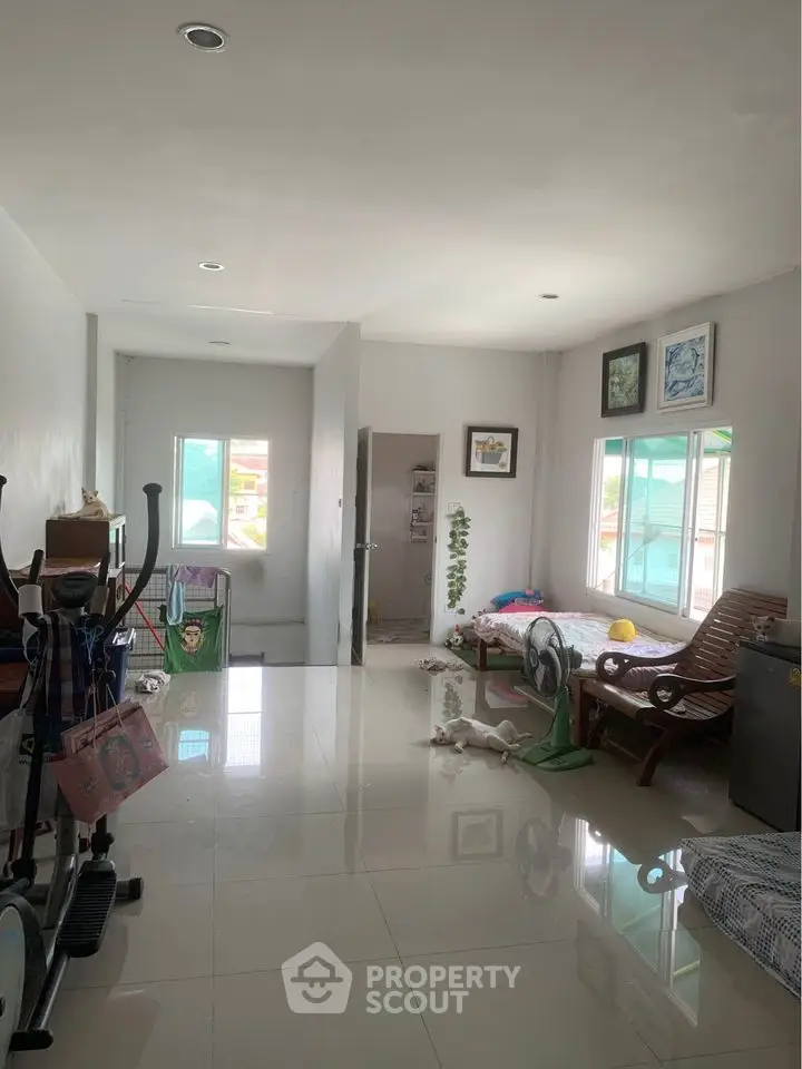 Spacious living area with natural light and modern decor in a cozy home setting.