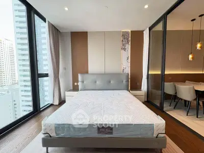 Modern bedroom with large windows and city view, featuring stylish decor and adjacent dining area.