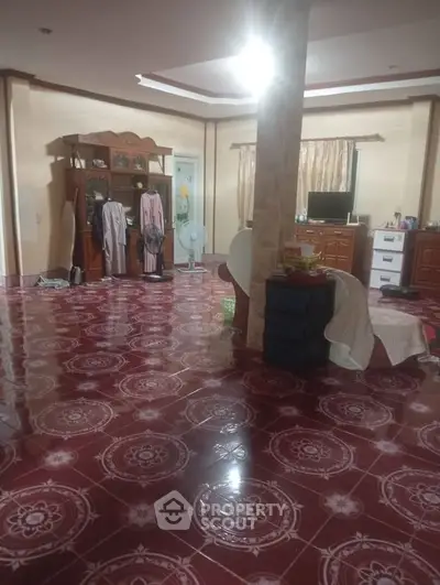 Spacious living room with unique tiled flooring and cozy furnishings, perfect for family gatherings.