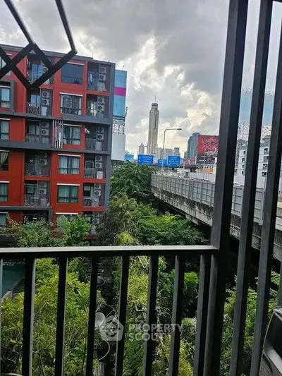 Urban apartment balcony with city view and lush greenery