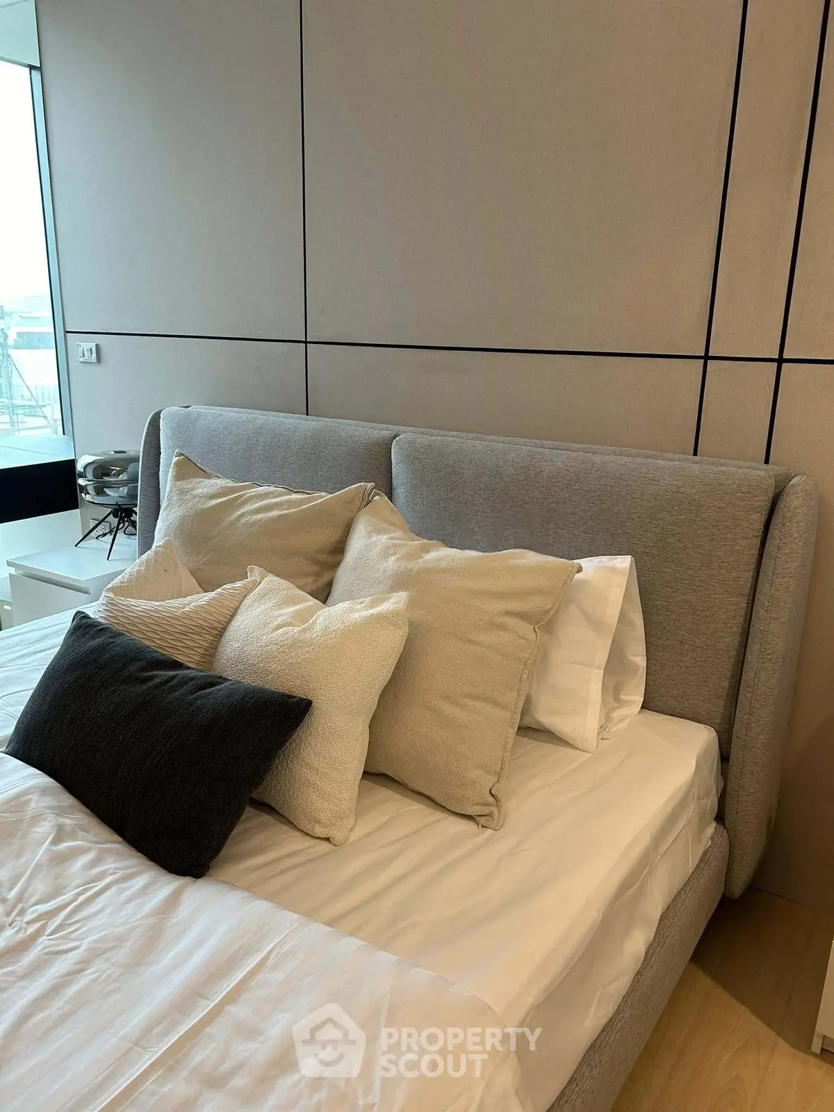 Modern bedroom with stylish decor and plush pillows, featuring a cozy bed and elegant design.