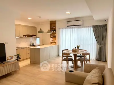 Modern open-plan living room and kitchen with stylish furniture and natural light.